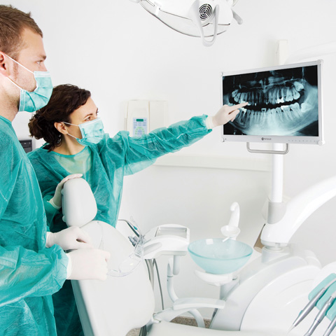 兩位醫護人員與牙科醫療顯示器示意 兩位醫護人員與牙科醫療顯示器示意